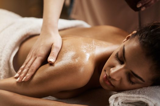 Close up photo of beautiful african girl enjoying massage in spa salon.